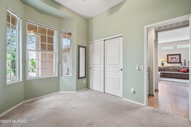 carpeted bedroom with a closet and multiple windows