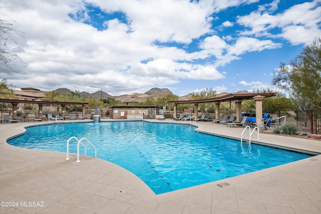 view of swimming pool featuring a mountain view and a patio