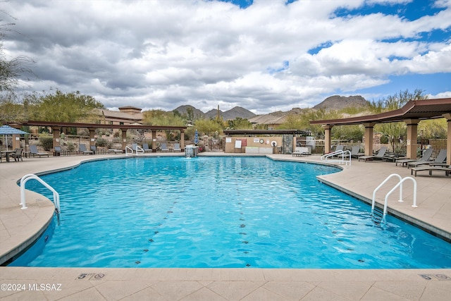 view of swimming pool featuring a patio area and a mountain view