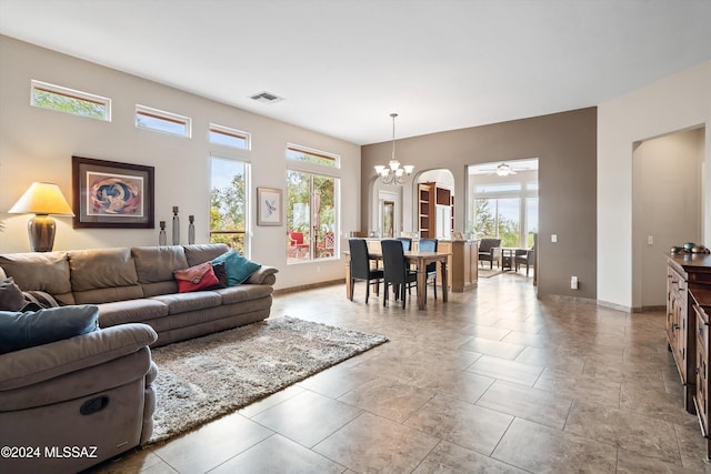 living room with ceiling fan with notable chandelier