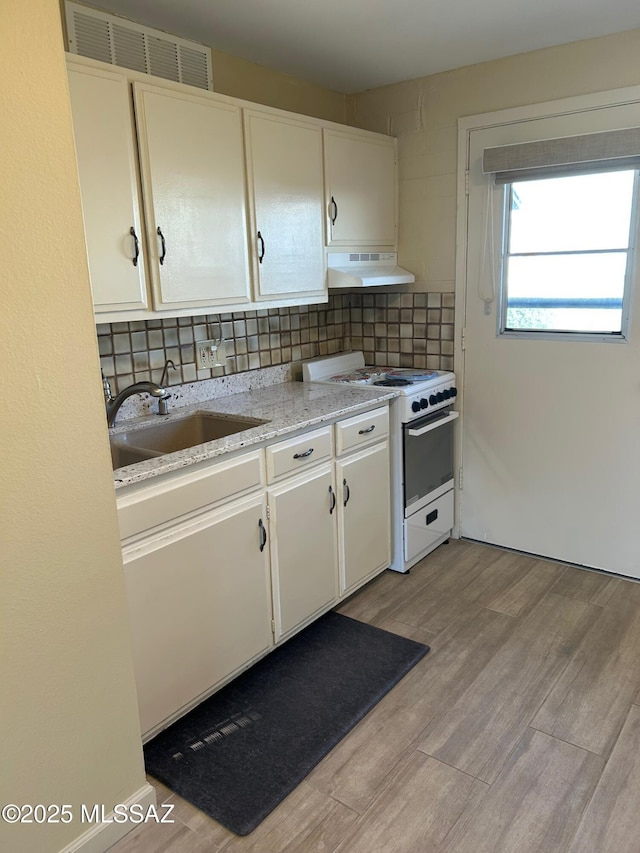 kitchen with white cabinetry, white range with gas cooktop, decorative backsplash, sink, and light hardwood / wood-style flooring