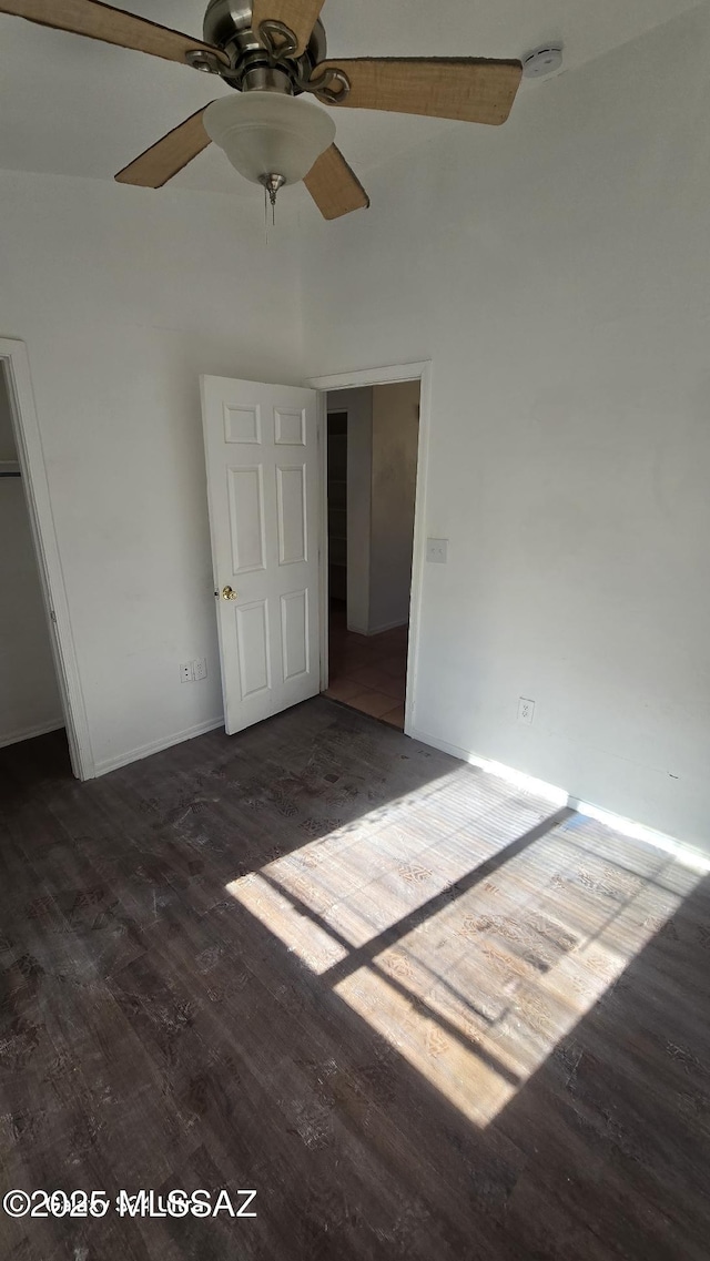 unfurnished bedroom with dark hardwood / wood-style flooring, a closet, high vaulted ceiling, and ceiling fan