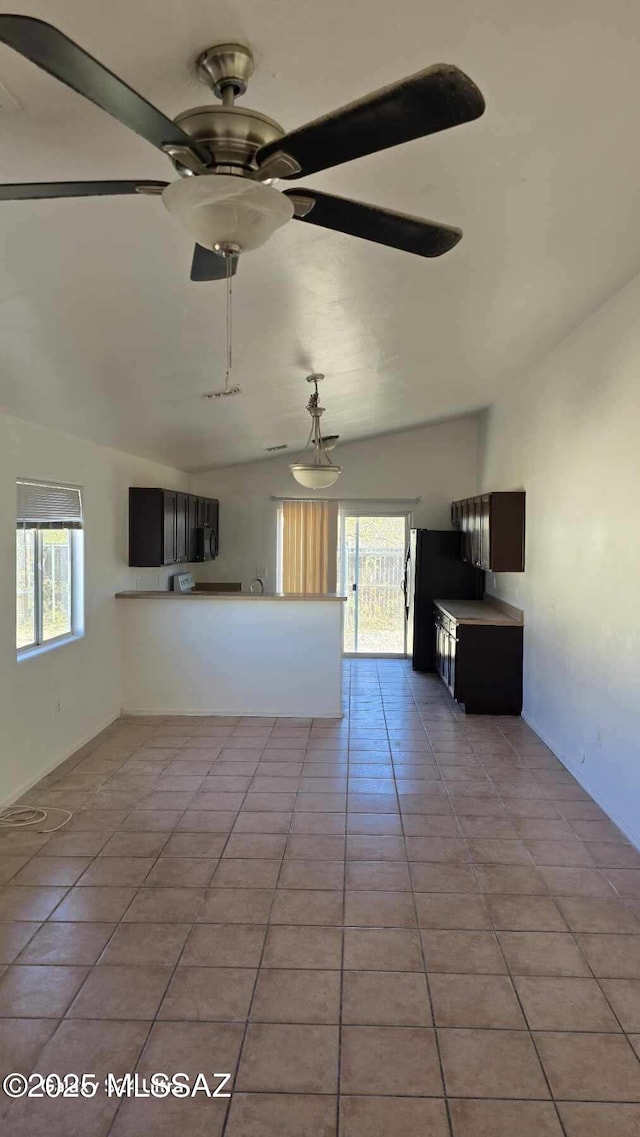 unfurnished living room with ceiling fan, light tile patterned flooring, and lofted ceiling