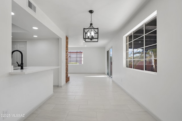 hall with sink and an inviting chandelier