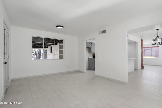 unfurnished room with a notable chandelier