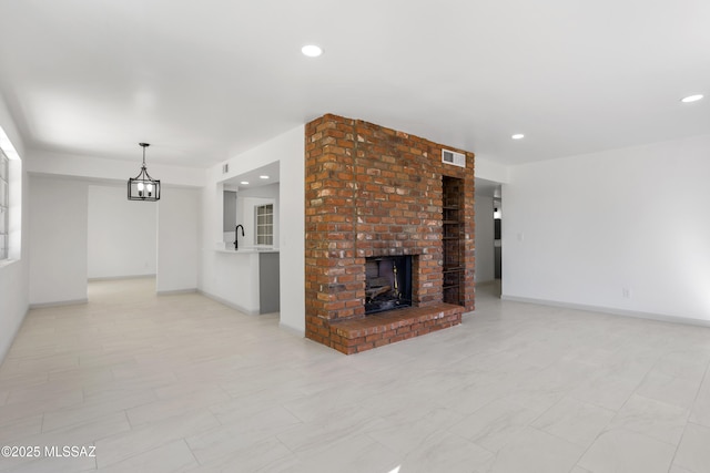 unfurnished living room with sink and a fireplace