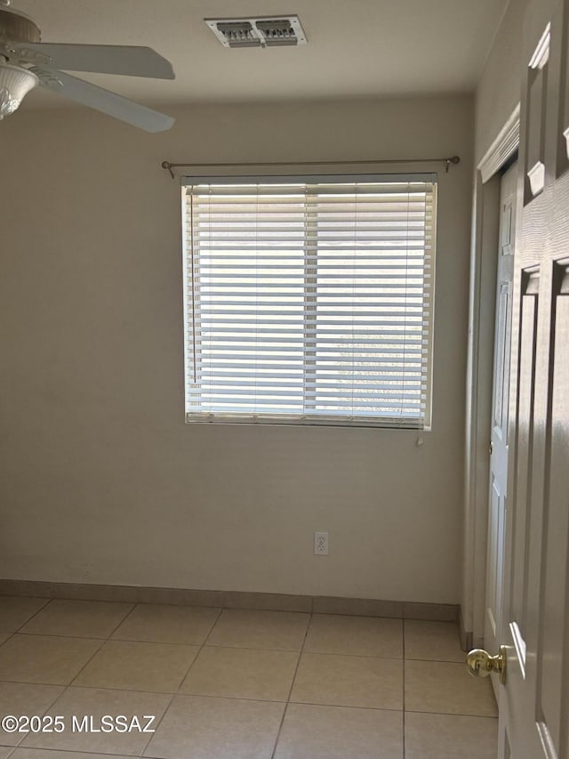 unfurnished room featuring light tile patterned floors, a wealth of natural light, and ceiling fan