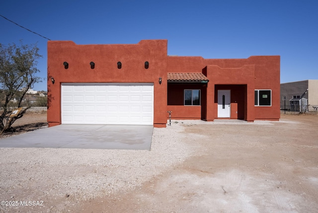 pueblo-style house featuring a garage