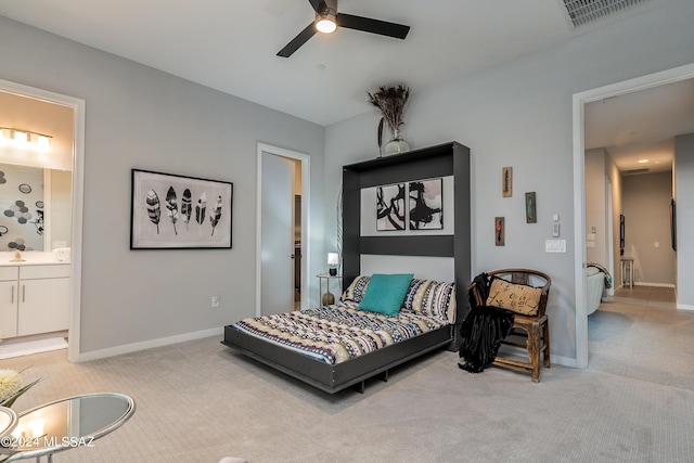 bedroom featuring ensuite bathroom, ceiling fan, and light colored carpet