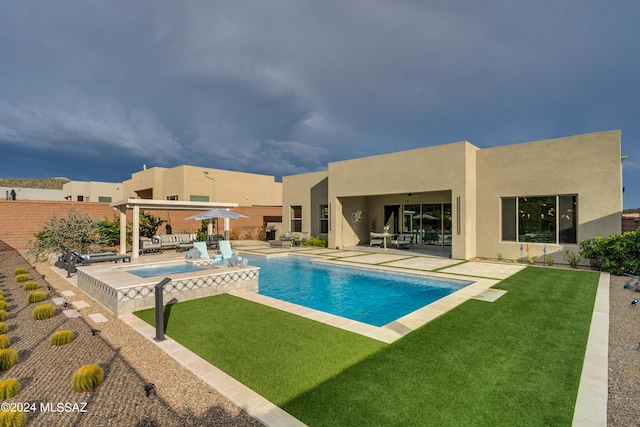 view of pool featuring a lawn, an in ground hot tub, and a patio