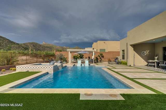 view of swimming pool featuring an in ground hot tub, a mountain view, and a patio