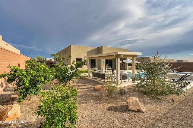 rear view of property featuring an outdoor living space and a patio