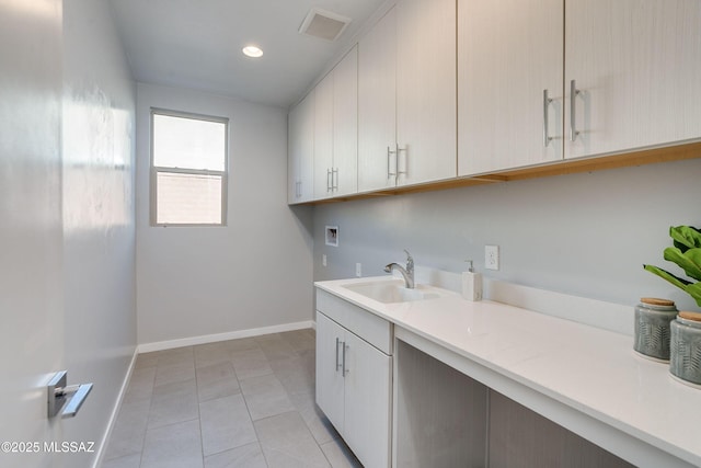 washroom with cabinets, light tile patterned floors, sink, and hookup for a washing machine