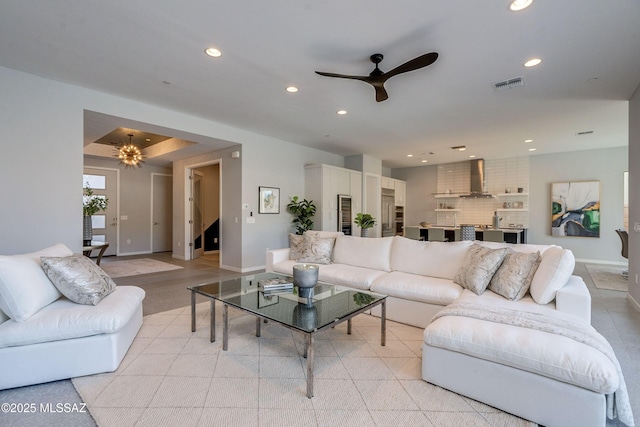 living room with ceiling fan with notable chandelier