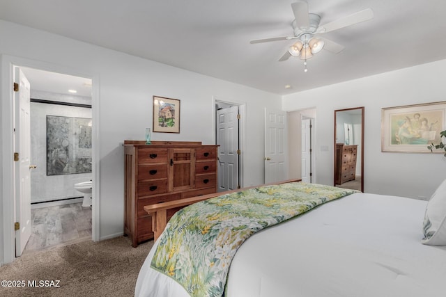 carpeted bedroom with ensuite bath and ceiling fan