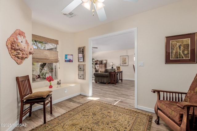 living area with light wood-type flooring and ceiling fan