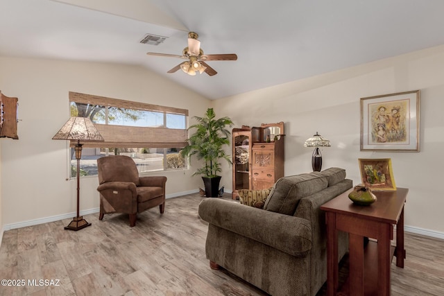 living room with ceiling fan, vaulted ceiling, and light hardwood / wood-style flooring