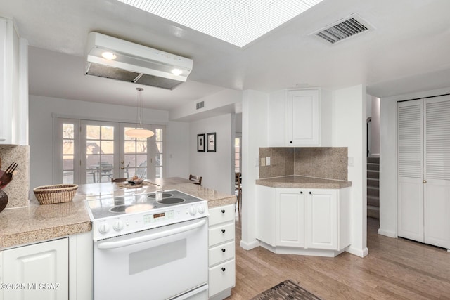 kitchen featuring decorative light fixtures, white cabinets, white electric stove, french doors, and decorative backsplash