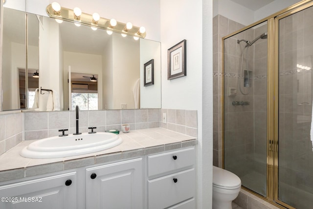 bathroom featuring toilet, walk in shower, backsplash, ceiling fan, and vanity