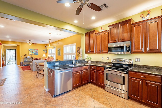 kitchen featuring visible vents, open floor plan, appliances with stainless steel finishes, a peninsula, and a ceiling fan