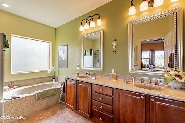 bathroom with double vanity, tile patterned flooring, a garden tub, and a sink