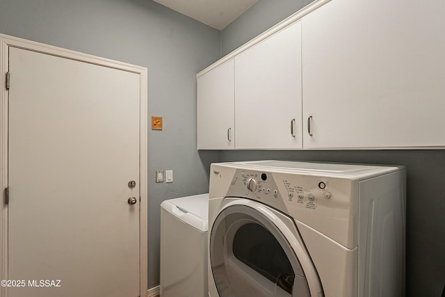 washroom featuring cabinet space and washing machine and dryer