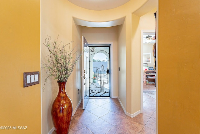 foyer entrance featuring light tile patterned floors and baseboards