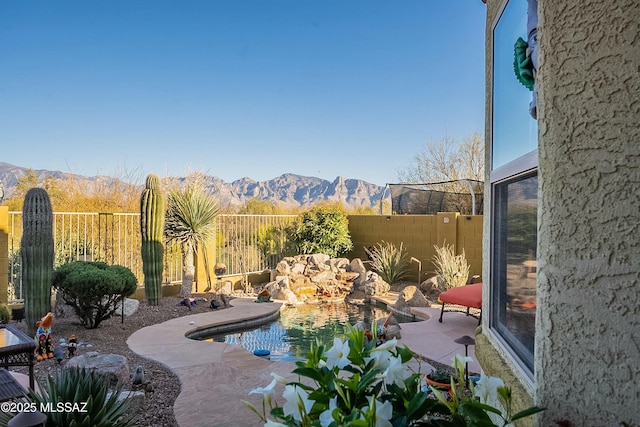 exterior space with a mountain view and a fenced backyard