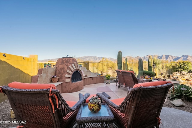 view of patio / terrace featuring a mountain view and fence