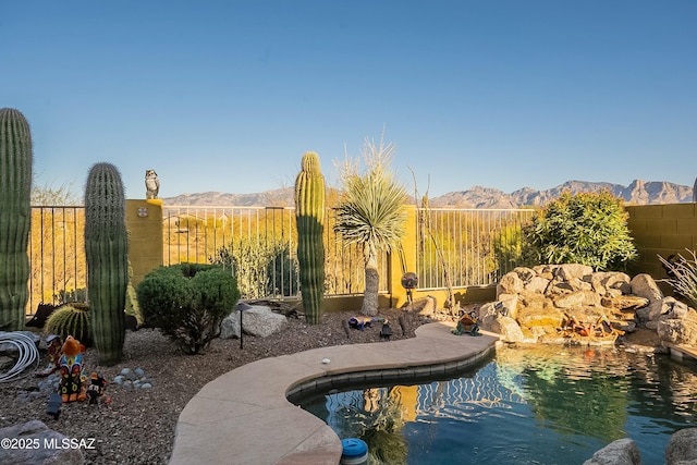 view of pool with a fenced in pool, a mountain view, and fence