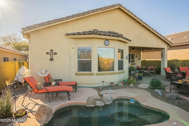 back of house with a patio area, stucco siding, a tiled roof, and fence