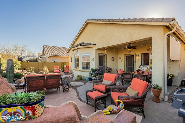 view of patio / terrace with an outdoor living space, ceiling fan, and fence