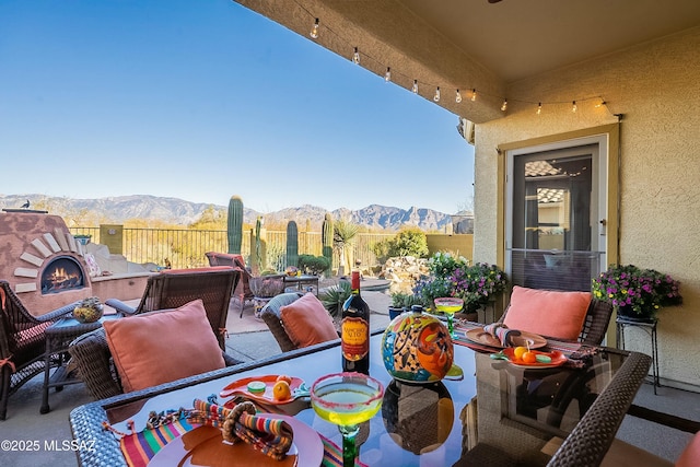 view of patio with outdoor lounge area, fence, and a mountain view