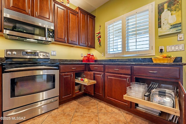 kitchen featuring dark countertops, light tile patterned flooring, dark brown cabinets, and stainless steel appliances