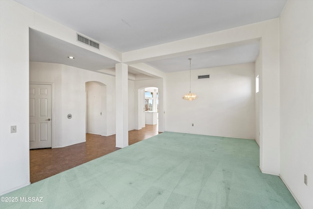 unfurnished room with a chandelier, plenty of natural light, and carpet floors