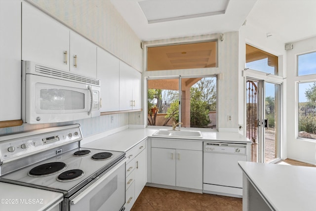 kitchen with sink, white appliances, white cabinetry, and light tile patterned floors