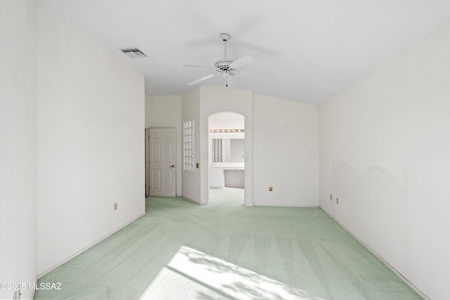 unfurnished room with ceiling fan, light colored carpet, and vaulted ceiling