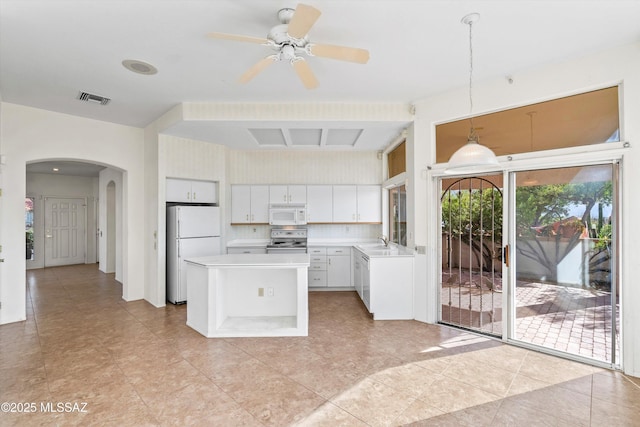 kitchen featuring white appliances, decorative light fixtures, white cabinetry, decorative backsplash, and sink