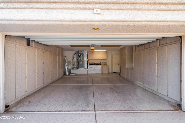 garage with gas water heater and washing machine and dryer