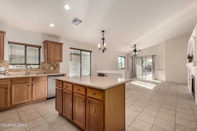 kitchen with sink, a center island, stainless steel dishwasher, backsplash, and pendant lighting