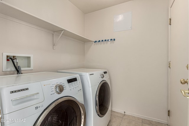 laundry room with washer and dryer and light tile patterned flooring