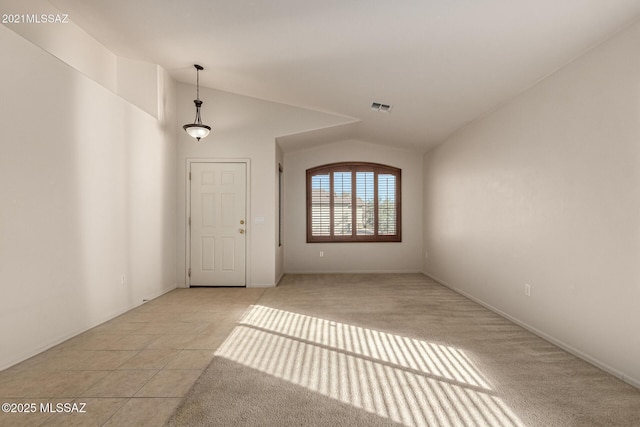 empty room featuring lofted ceiling and light carpet