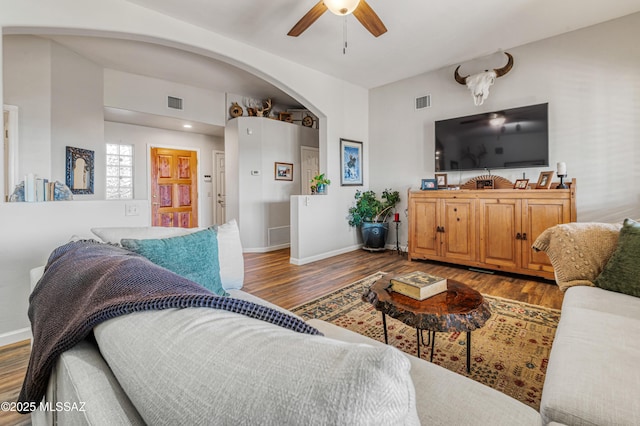 living room featuring ceiling fan and dark hardwood / wood-style flooring