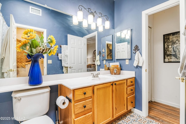 bathroom with toilet, vanity, and tile patterned flooring