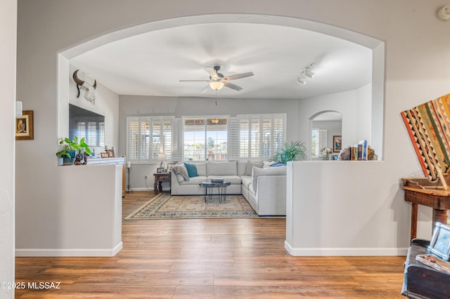 living room featuring ceiling fan and hardwood / wood-style flooring