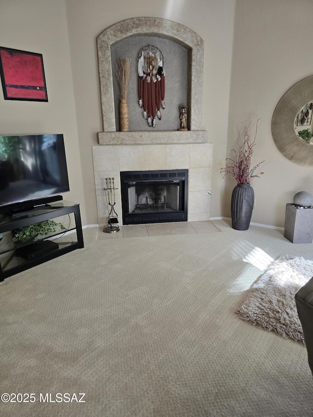 living room featuring carpet and a tiled fireplace