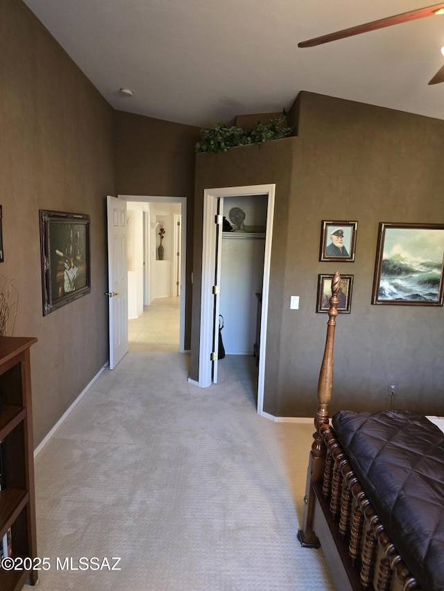 bedroom with a closet, ceiling fan, and light colored carpet