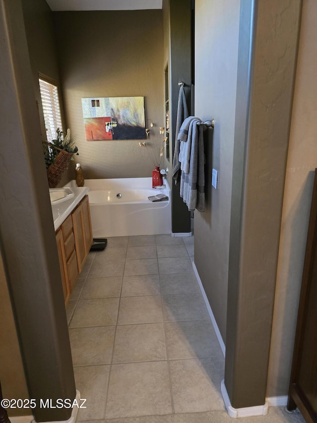 bathroom with a bathing tub, tile patterned floors, and vanity