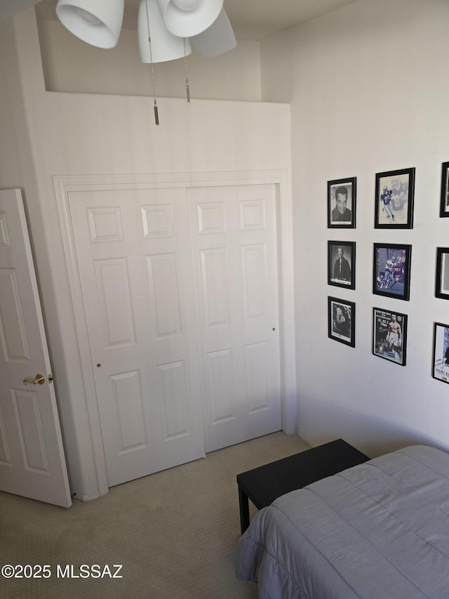 bedroom featuring ceiling fan, a closet, and light carpet