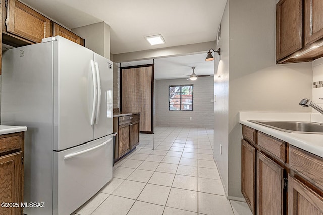 kitchen featuring white refrigerator, light tile patterned flooring, ceiling fan, and sink